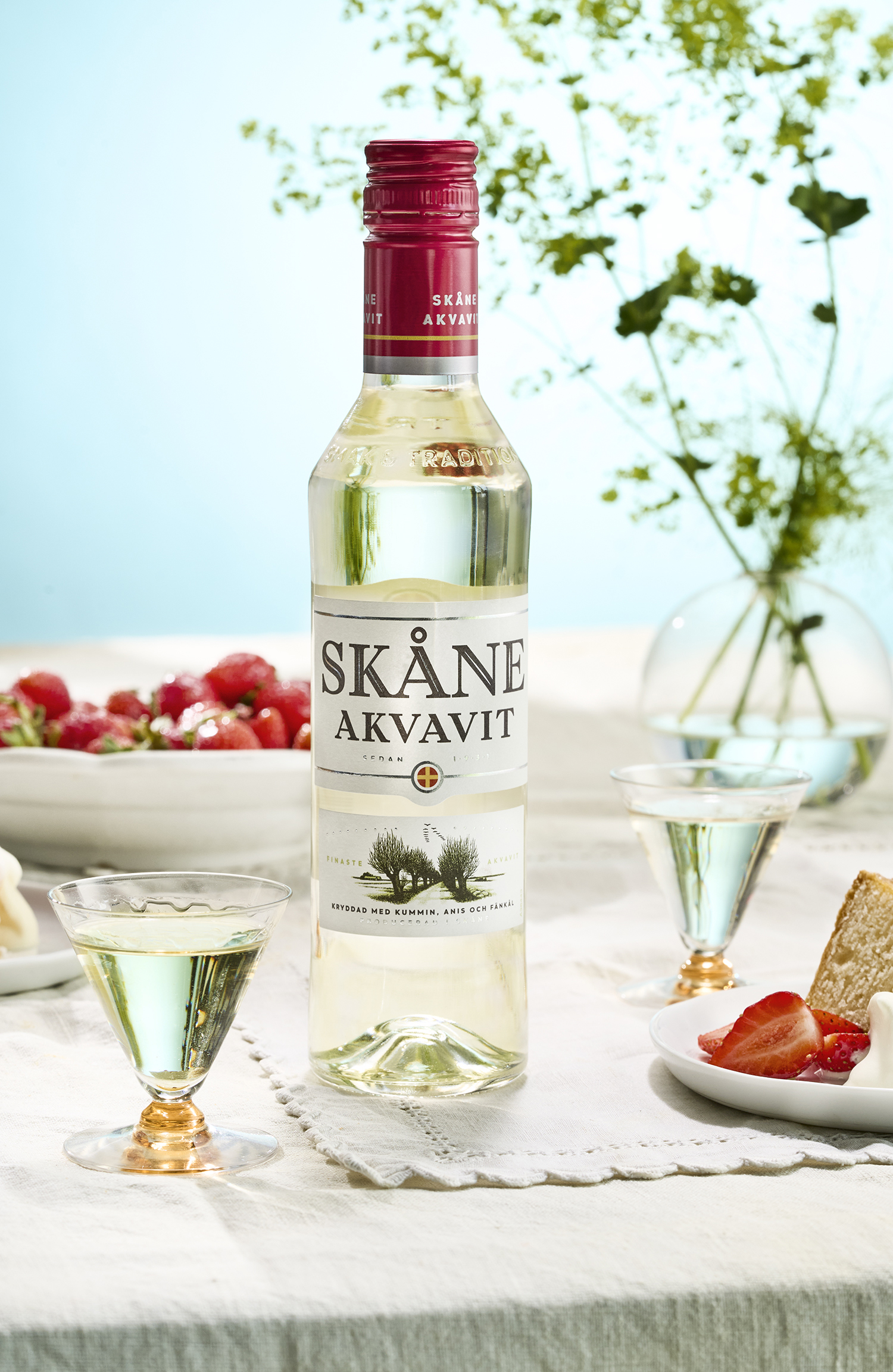 Skåne Akvavit på midsommarbordet med jordgubbar och tårta